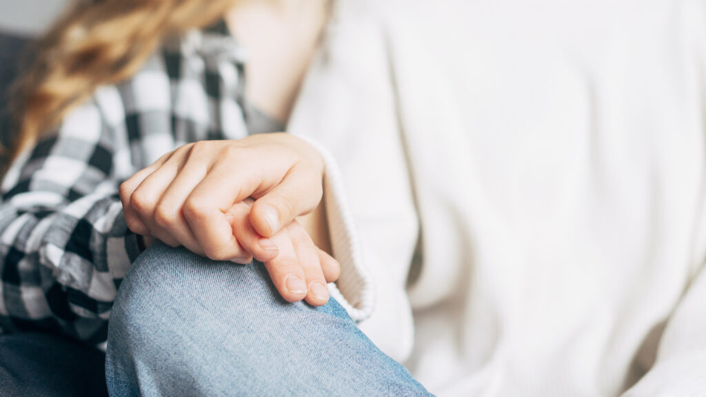 Mano de una persona ofreciendo apoyo emocional a otra, símbolo de acompañamiento y prevención del suicidio.