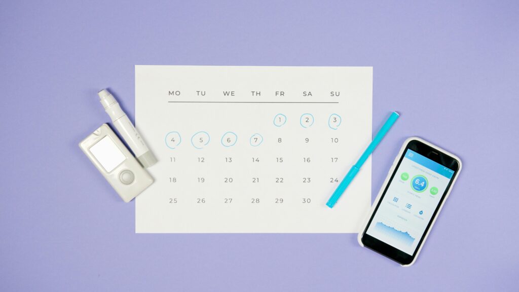 Agenda con calendario y teléfono móvil representando el seguimiento psicológico del dolor crónico y la planificación de sesiones de terapia.
