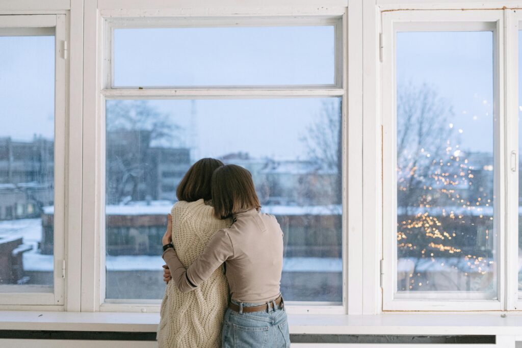 Abrazo en invierno que refleja apoyo emocional en el duelo navideño.