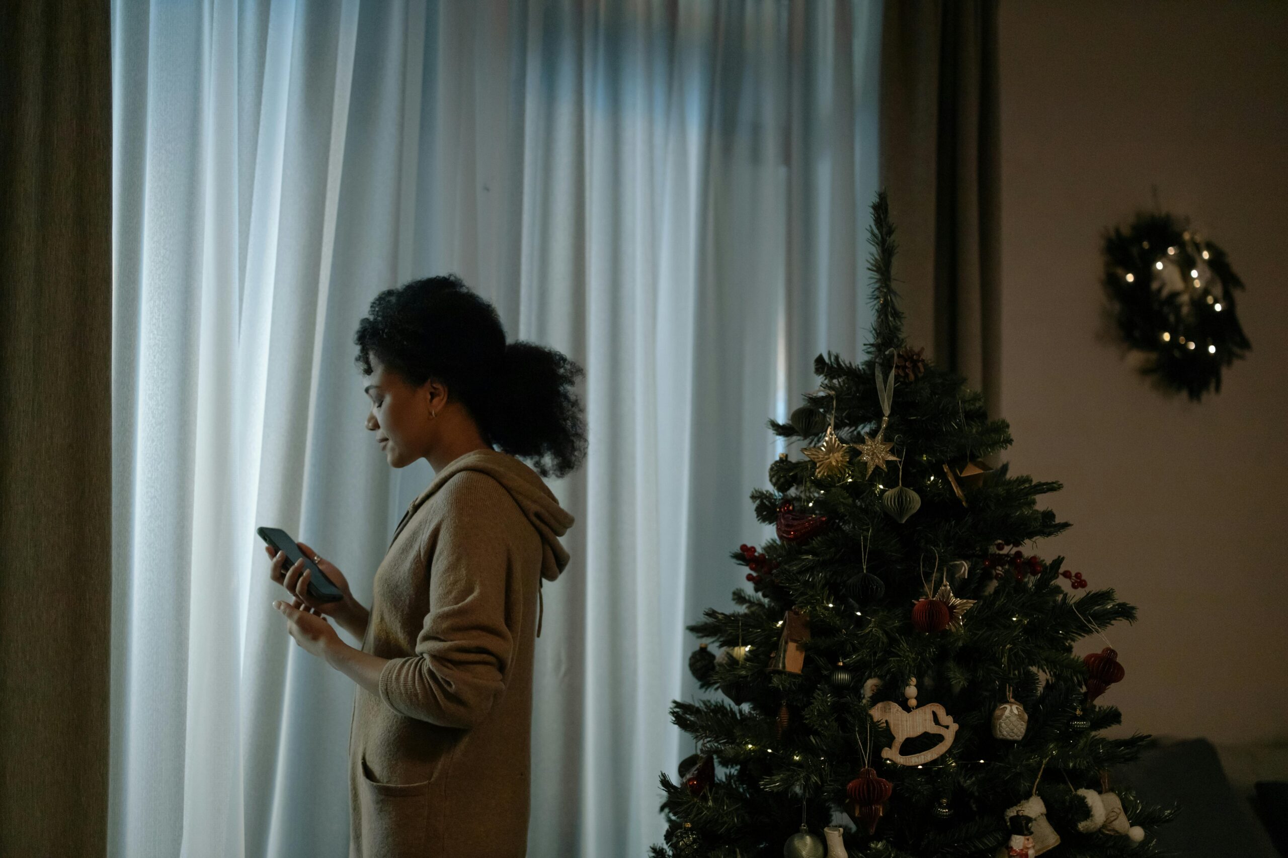 Mujer junto al árbol de Navidad en un momento de reflexión y duelo