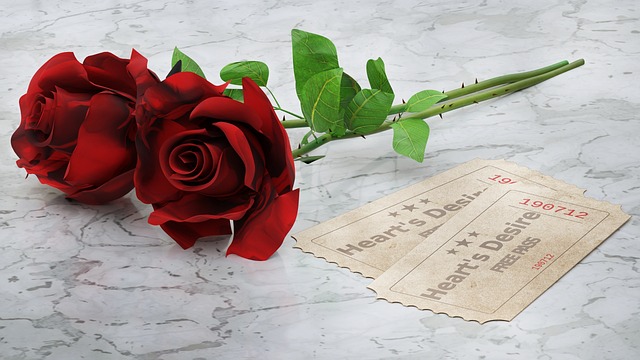 Rosas rojas junto a entradas, símbolo de romanticismo y deseo; imagen para hablar de por qué puede disminuir el deseo sexual en la relación afectiva.