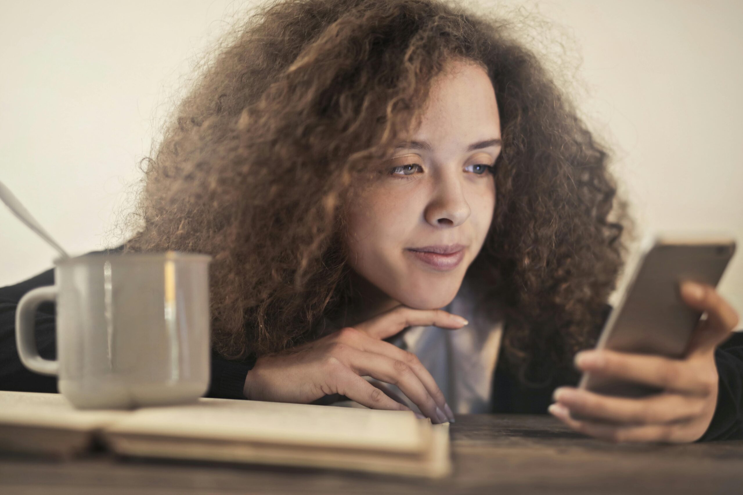 Joven usando el móvil en casa, imagen relacionada con chatbots de IA, terapia psicológica y búsqueda de ayuda emocional.