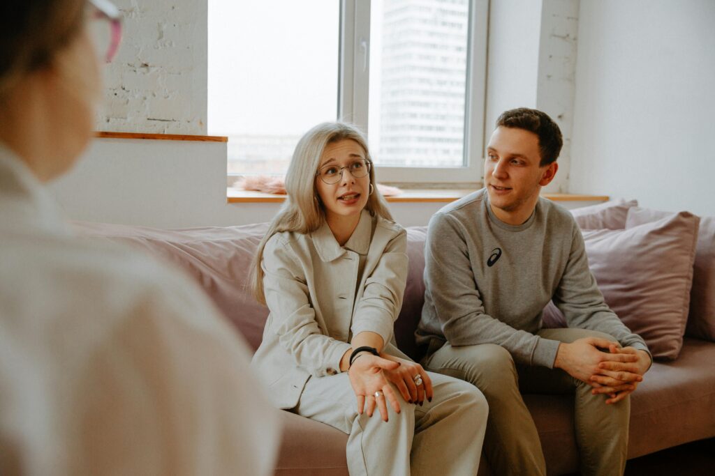 Pareja en sesión de terapia de pareja hablando con un profesional, imagen sobre los cuatro jinetes de Gottman y la relación.