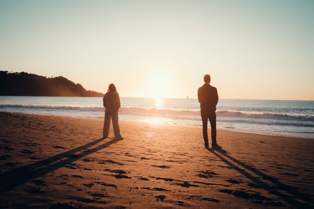 Pareja caminando frente al mar, imagen sobre comunicación, reencuentro y mejora de la relación durante las vacaciones de verano.